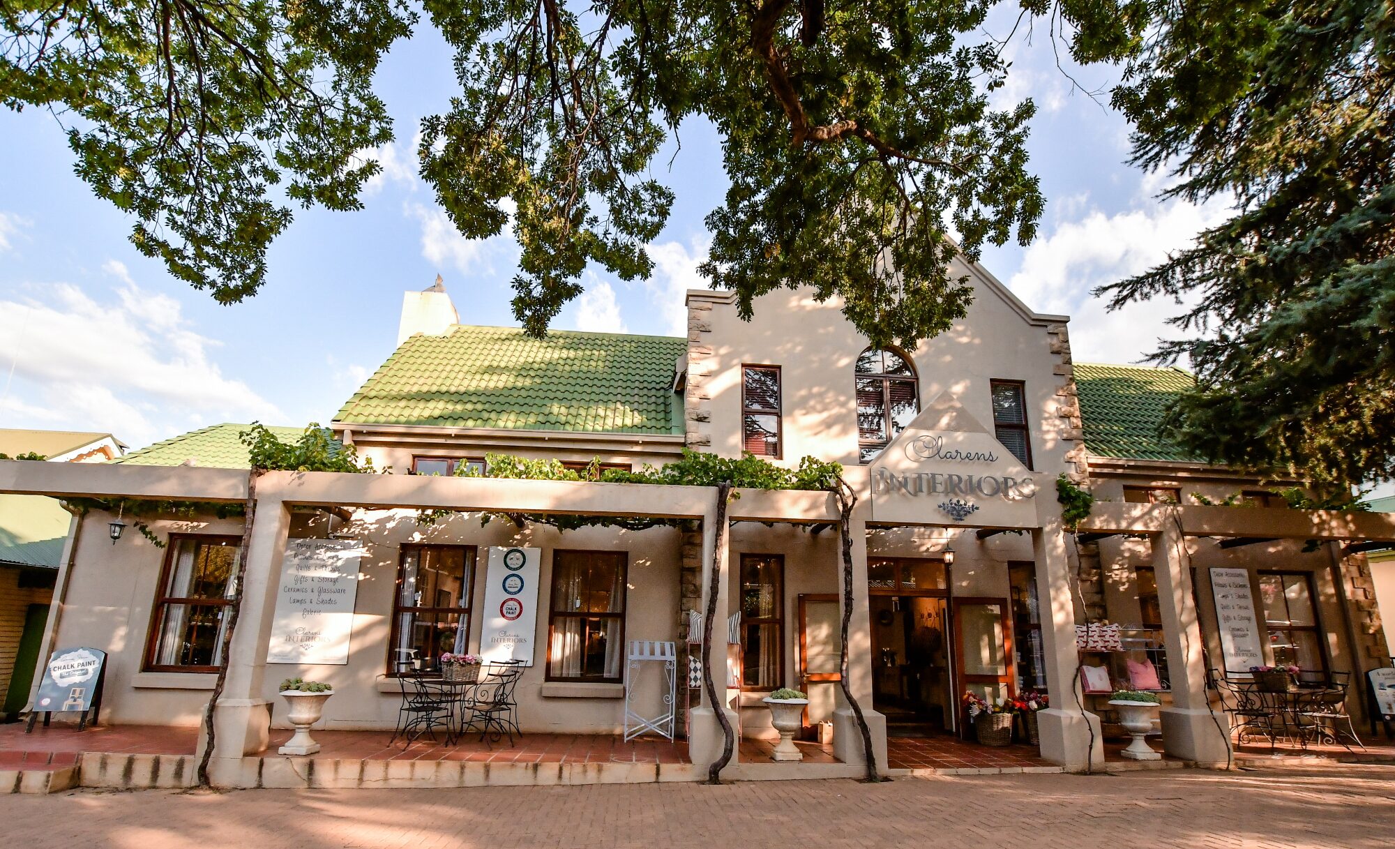 Sandstone shopfronts and shady trees on Main Street in Clarens village